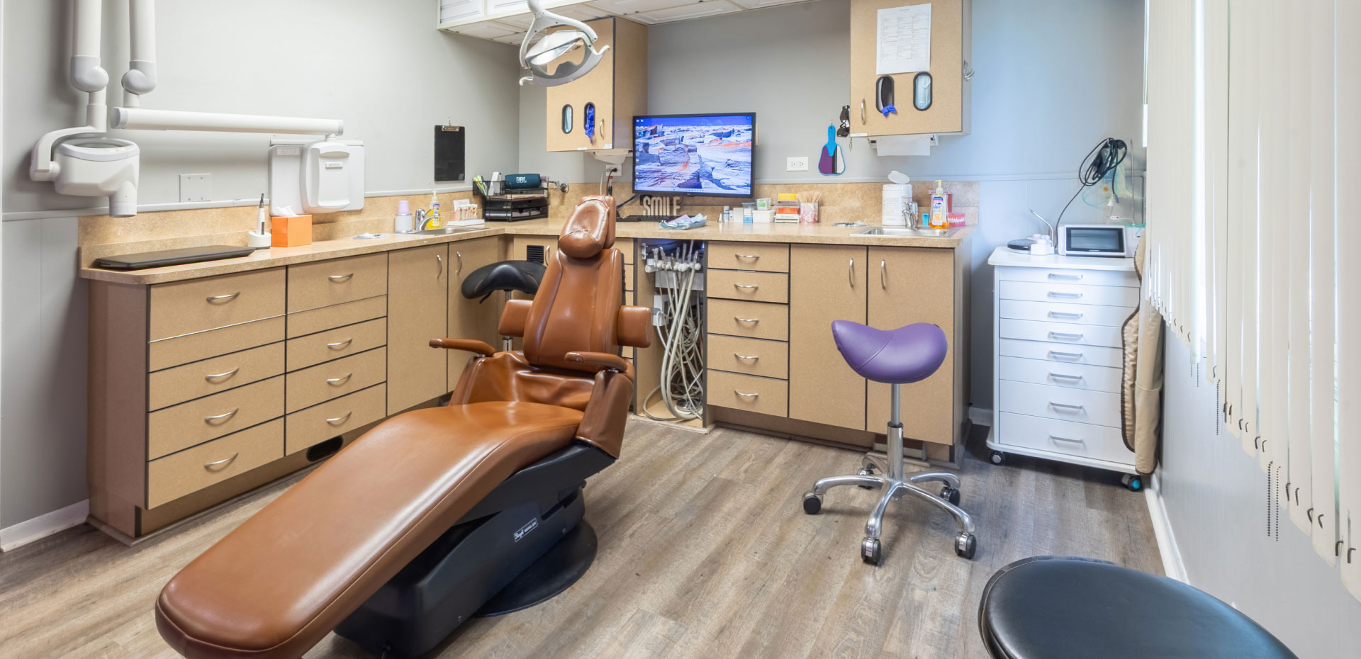 exam room with cabinets, dental chair and equipment