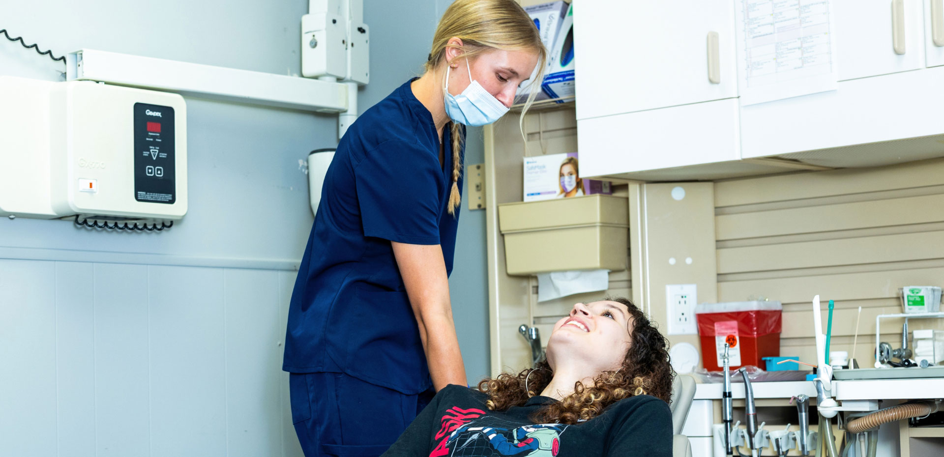 Assistant helping patient prepare for dental exam